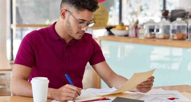 Hands arranging colorful sentence cards on a study desk for PTE Reorder Paragraphs practice in Australia